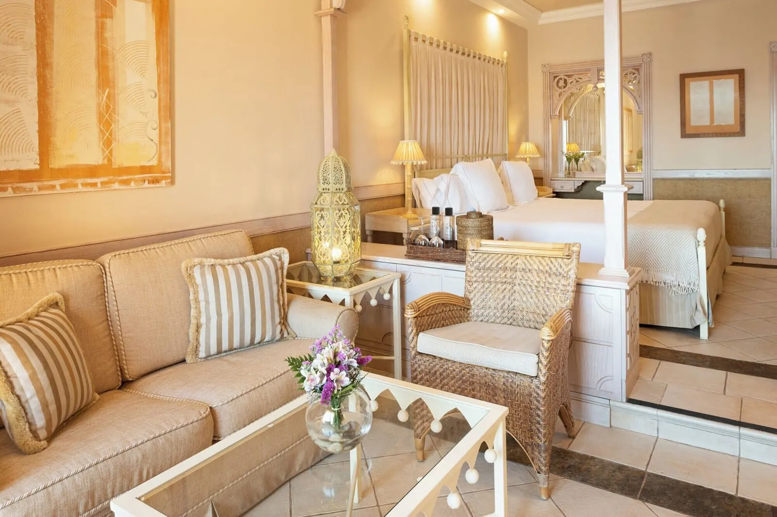 JOIA El Mirador by Iberostar: A hotel room with a sofa, a small table with a vase of flowers, a wicker chair