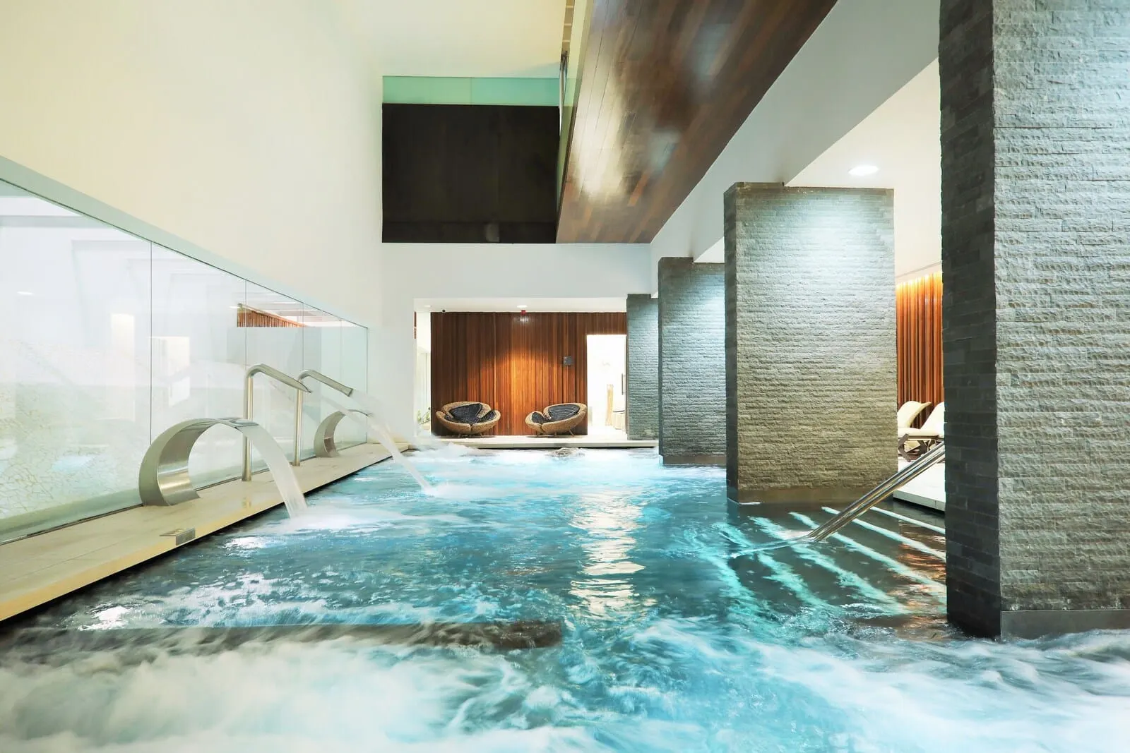 JOIA Salomé by Iberostar: A hot tub area with a wooden floor, stone walls, and two wicker chairs