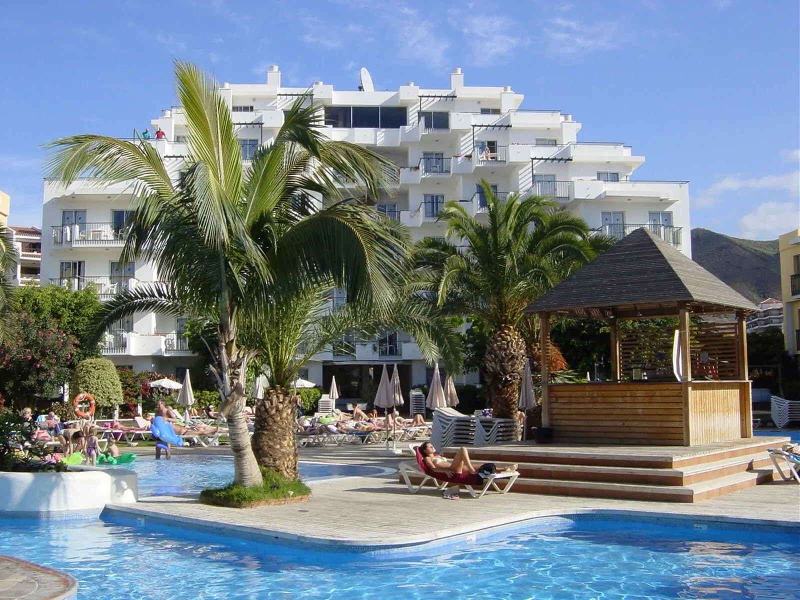 HG Tenerife Sur: A pool area with lounge chairs, palm trees