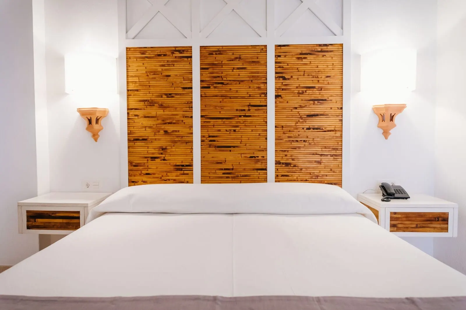 Apartamentos Parque del Sol: A hotel room with a large bed, wooden headboard, two bedside tables with lamps