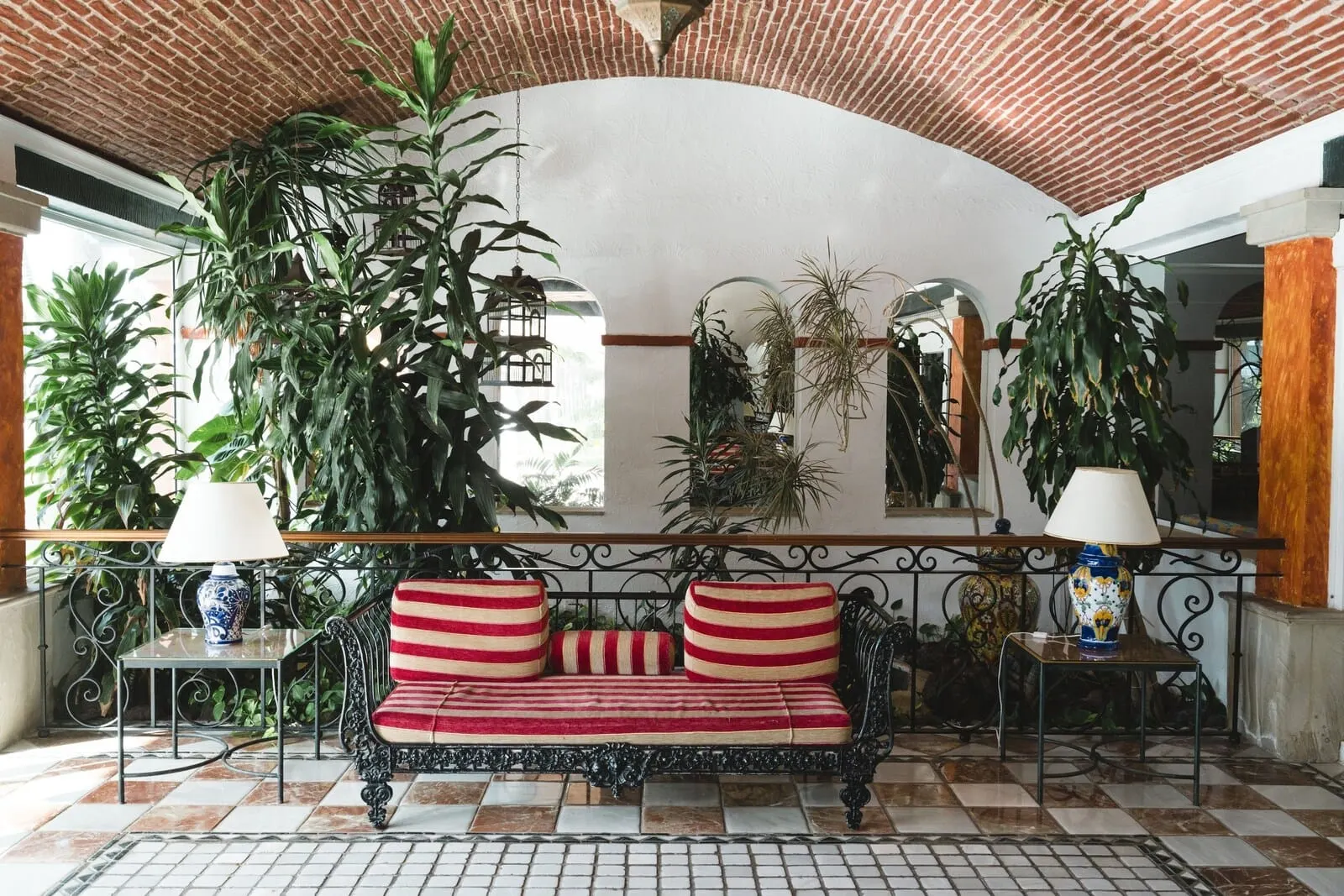 Park Club Europe: A cozy lounge area with a red and beige striped sofa, two side tables with lamps