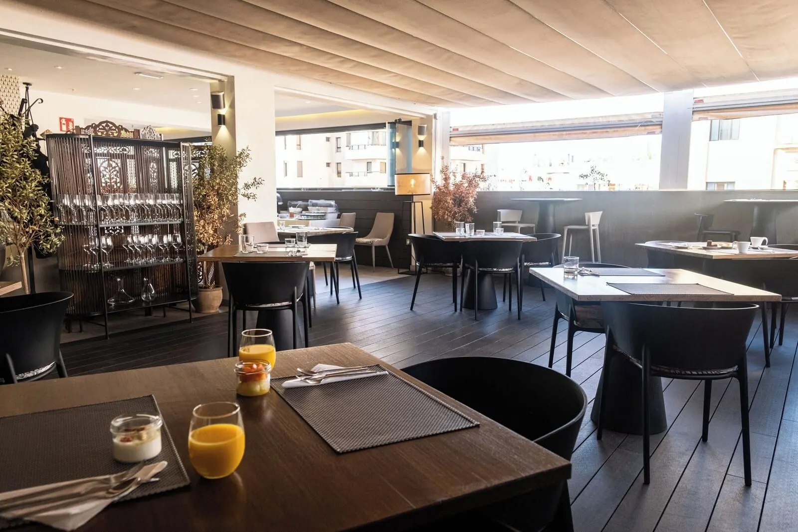 Adonis La Suite: A modern dining area with wooden flooring, black chairs