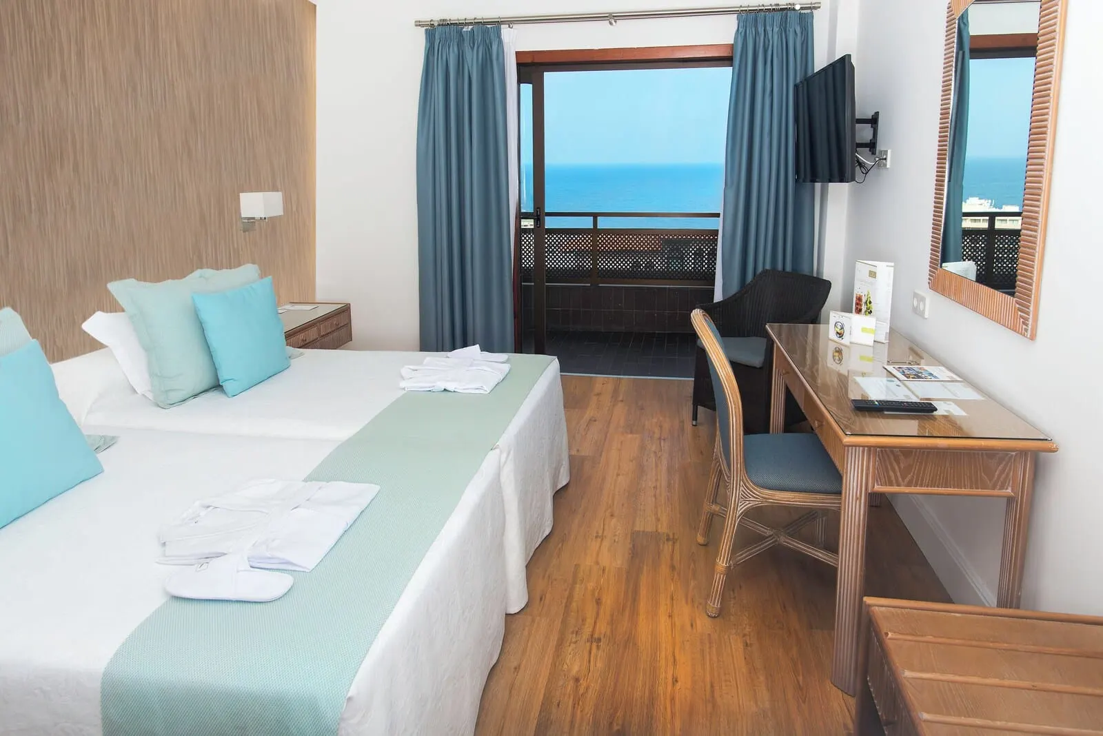 FERGUS Puerto de la Cruz: A hotel room with a bed, a desk, a chair, a TV, and a view of the sea