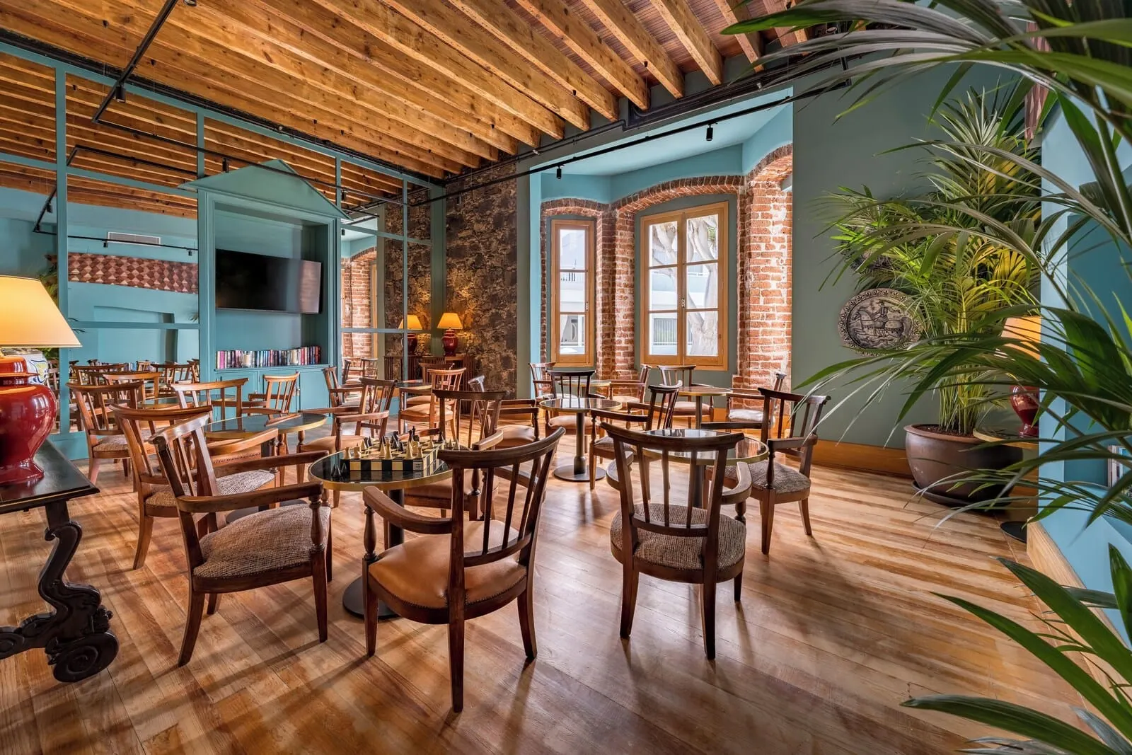 TUI BLUE Atlantic Hills: A spacious dining area with wooden tables and chairs, a brick wall, and large windows