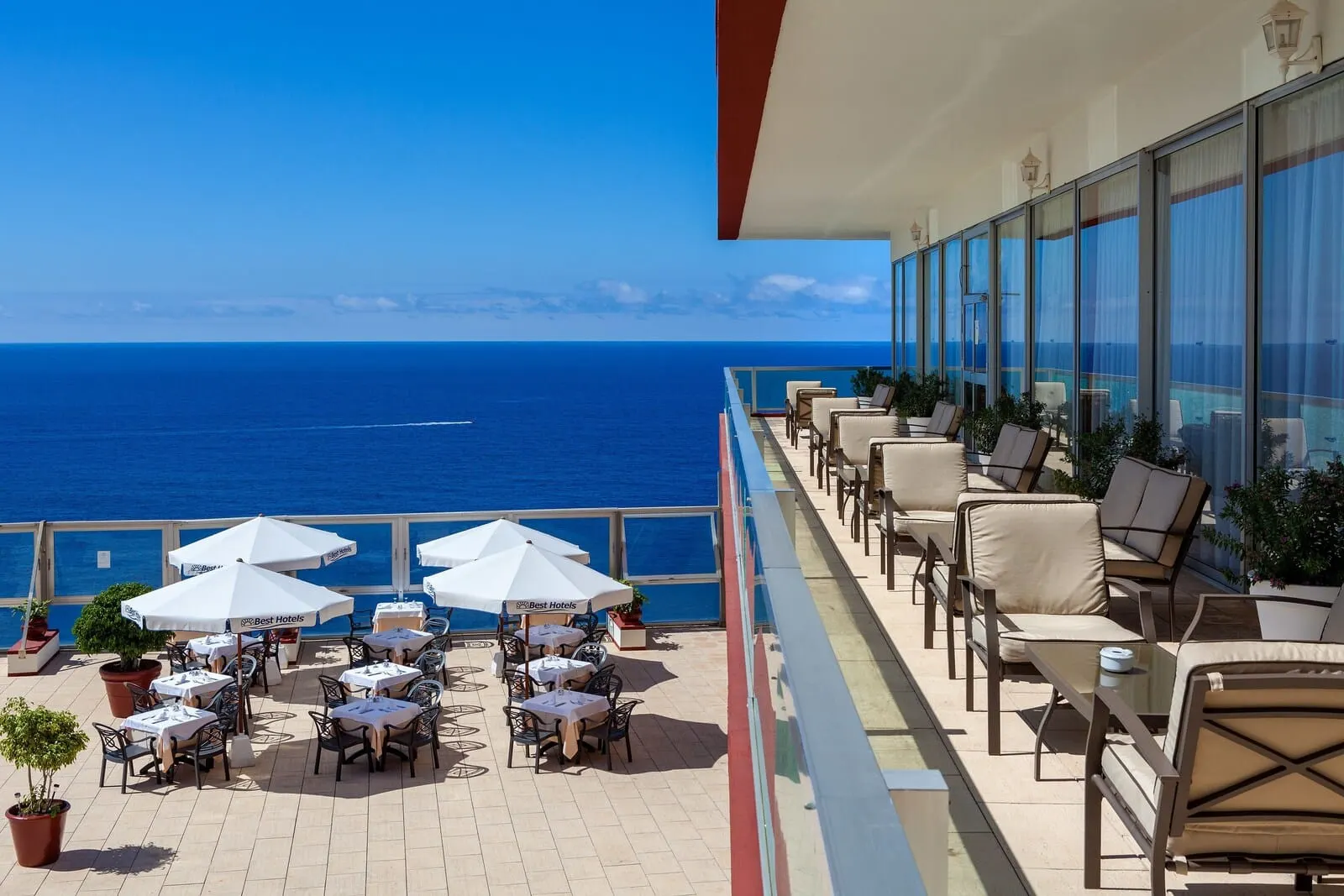 Best Semiramis: A sunlit outdoor dining area with tables and chairs, large umbrellas