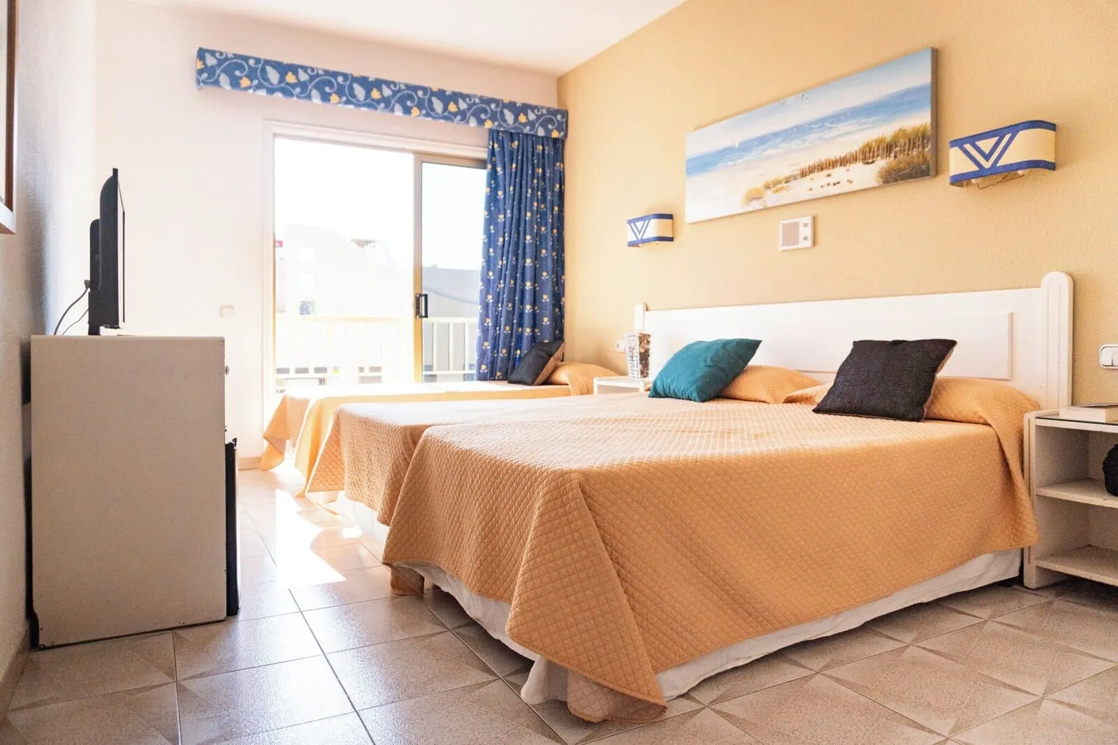 Hotel Aeropuerto Sur: A hotel room with two beds, a TV, a balcony, and a painting of a beach scene