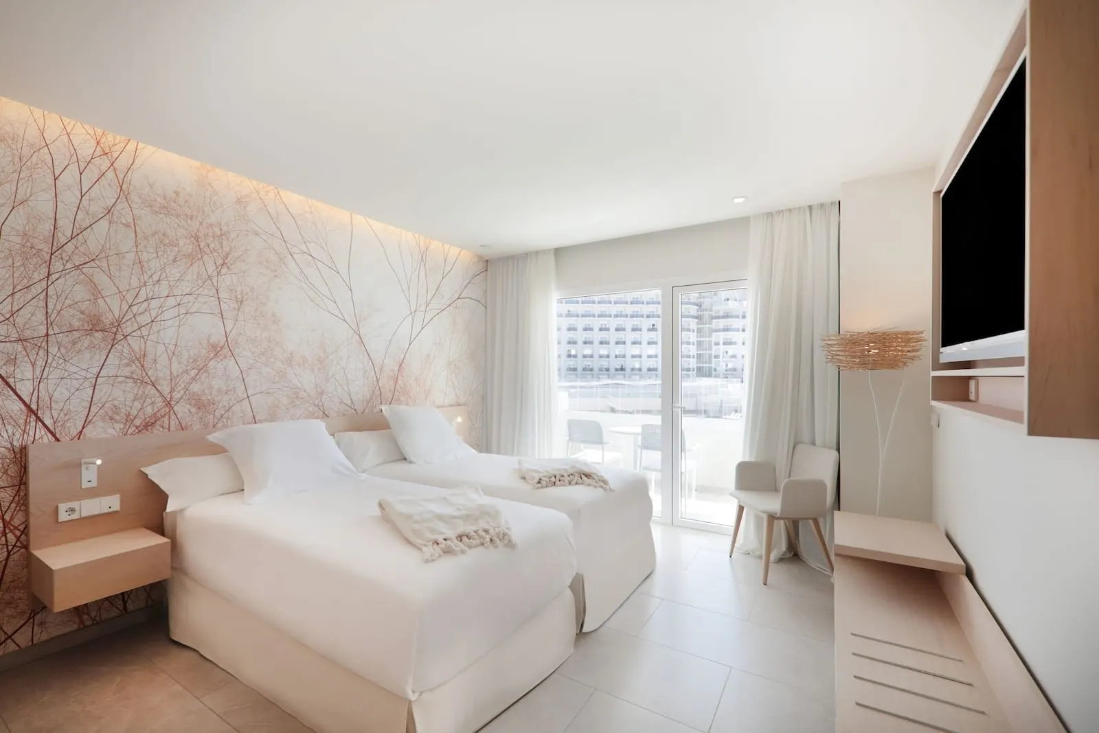 Iberostar Selection Sábila: A modern hotel room with two beds, a desk, and a TV