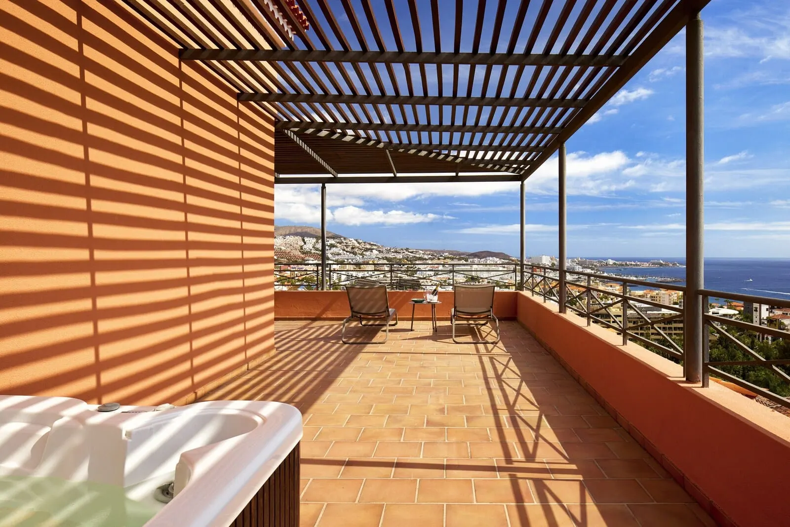 Meliá Jardines del Teide: A terrace with a view of the sea, a hot tub, and two chairs