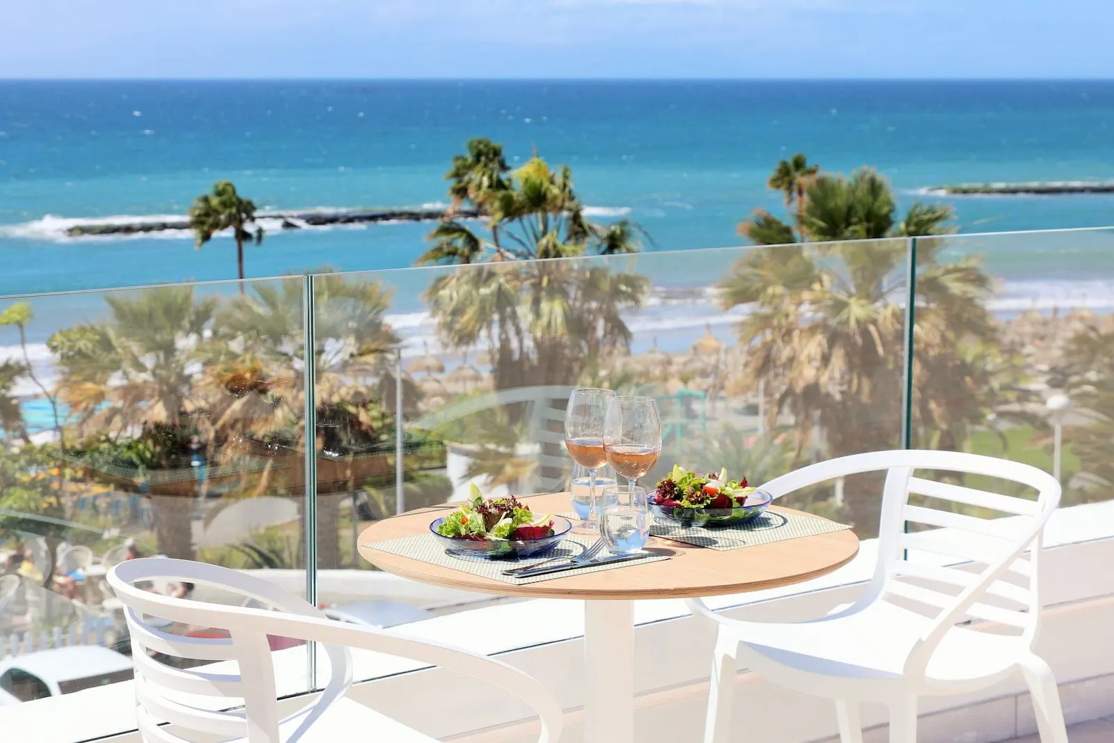 Iberostar Selection Sábila: A table with two chairs, a glass of water, and a glass of wine