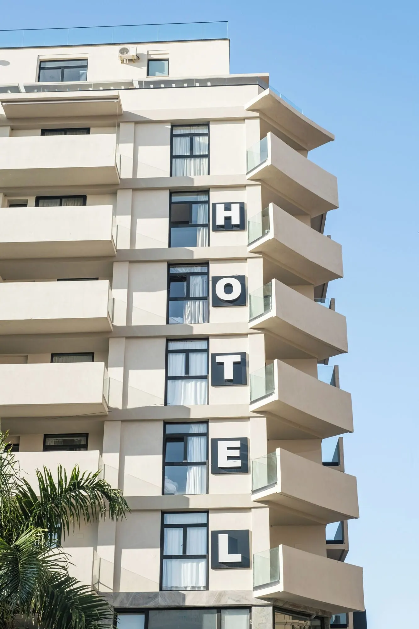Hotel Adonis Capital: A multi-story hotel with balconies and large windows