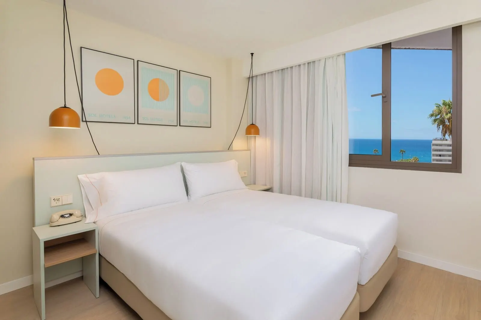 Sol Arona Tenerife: A hotel room with a bed, a nightstand, a telephone, and a window with a view of the sea