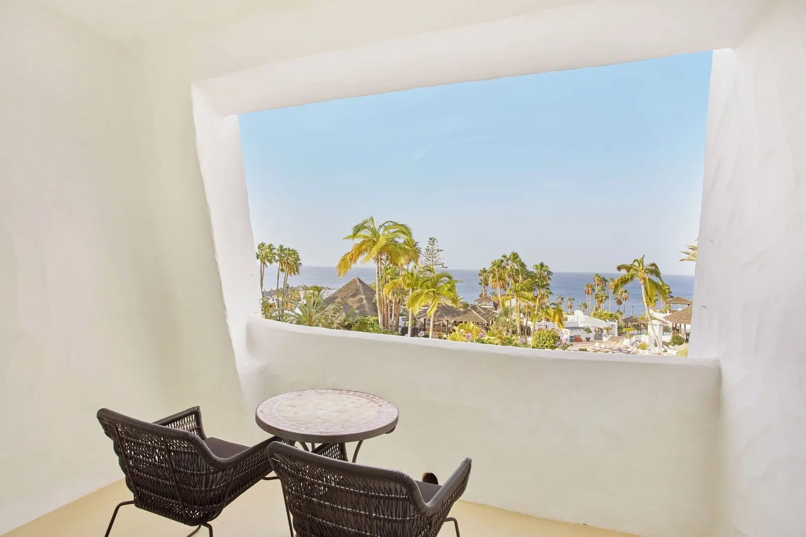 Hyatt Ziva Jardín Tropical Tenerife: A balcony with wicker chairs and a small table