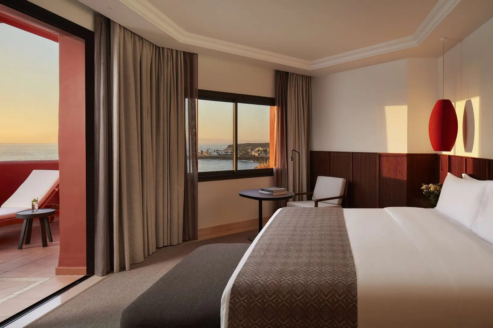 Tivoli La Caleta Tenerife Resort: A hotel room with a large bed, a small table, a chair, and a view of the sea