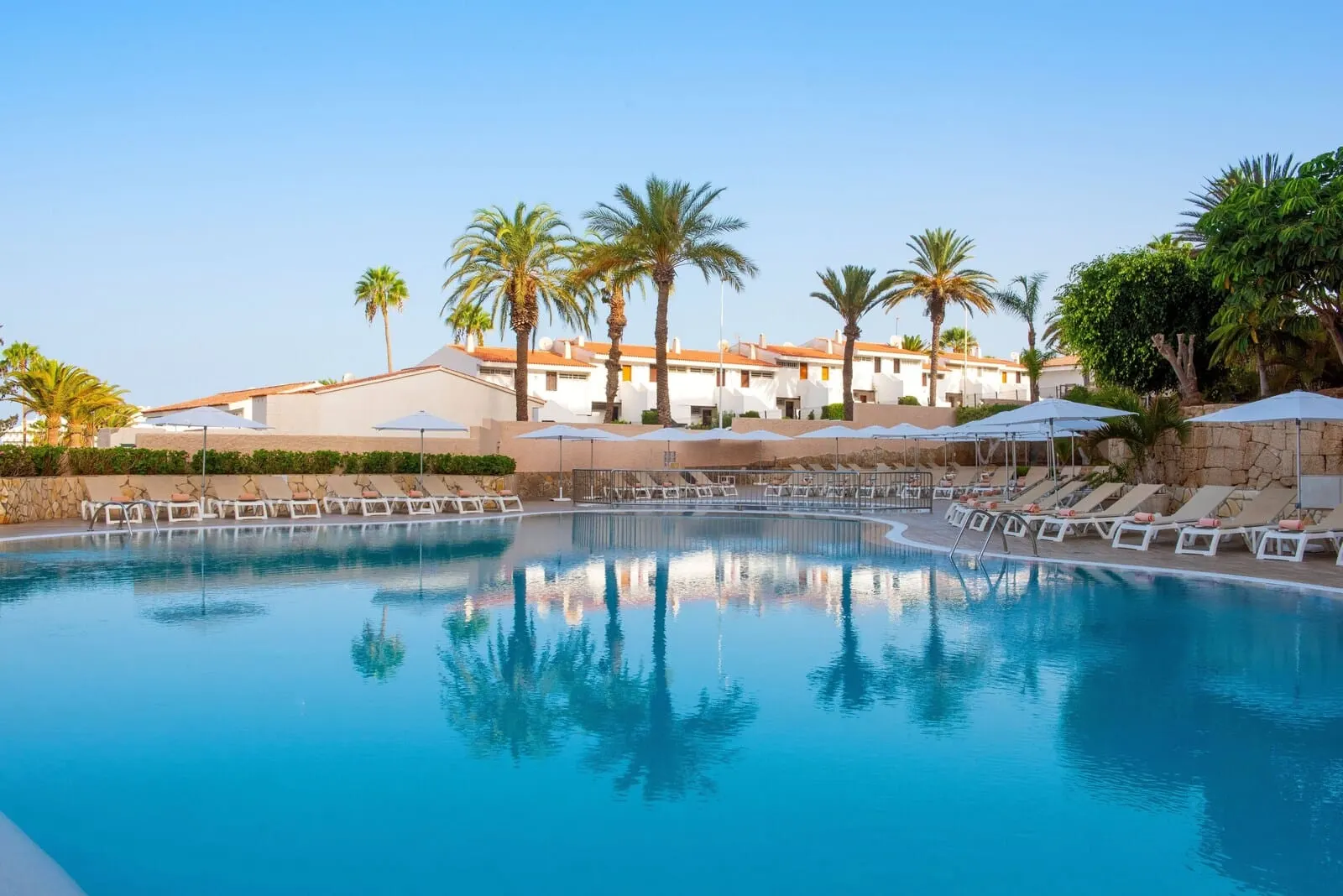 Olé Tropical Tenerife: A swimming pool with lounge chairs and umbrellas