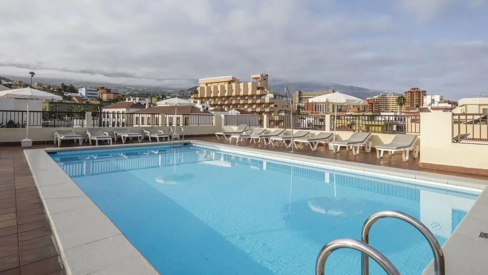 Be Smart Florida Plaza: A rooftop swimming pool with lounge chairs and a city view