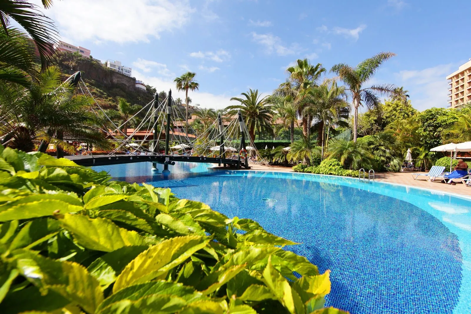 Bahia Principe Explore San Felipe: A swimming pool with clear blue water, surrounded by lush greenery and palm trees