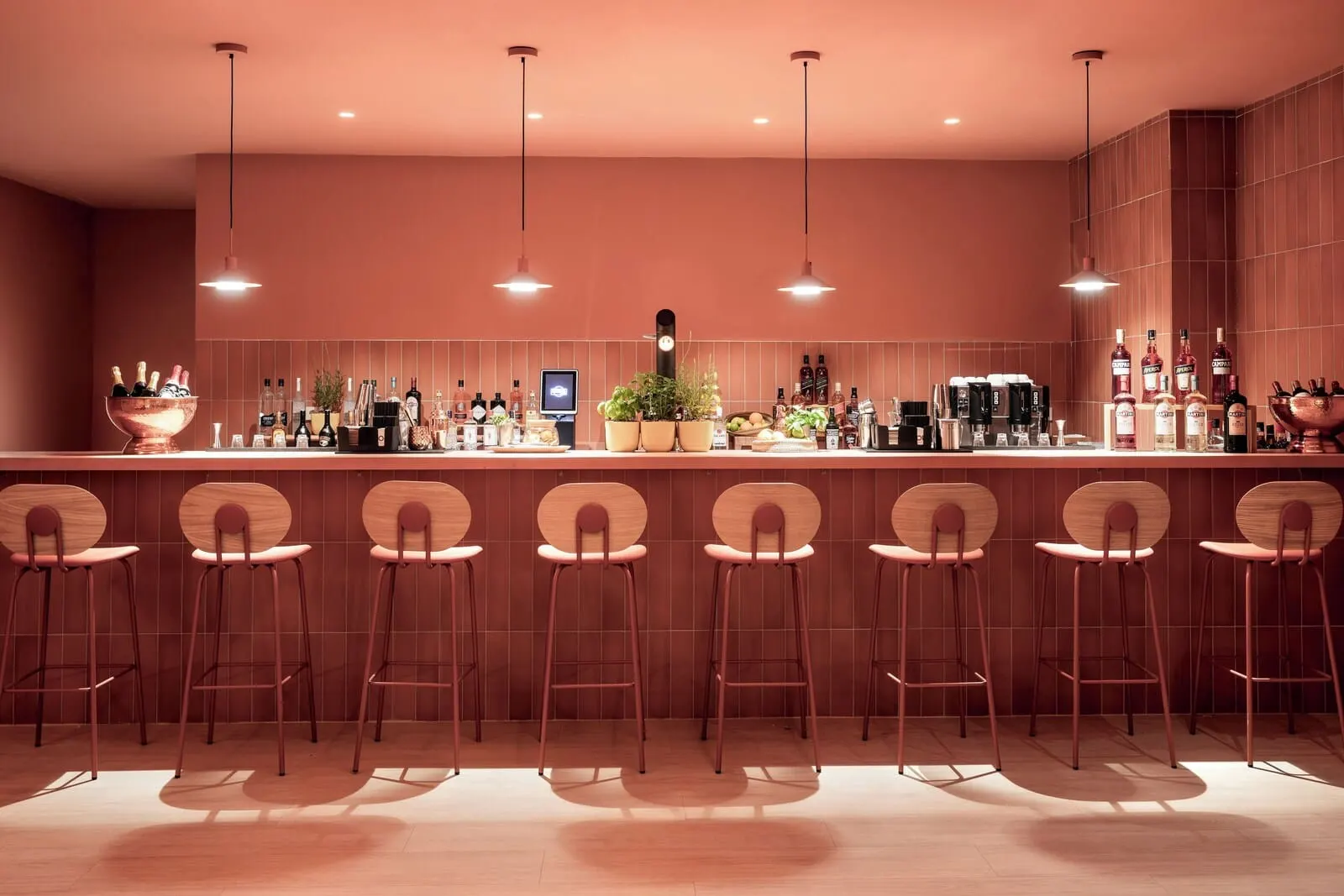 Sol Arona Tenerife: A bar area with multiple stools, a clock, and various bottles and glasses