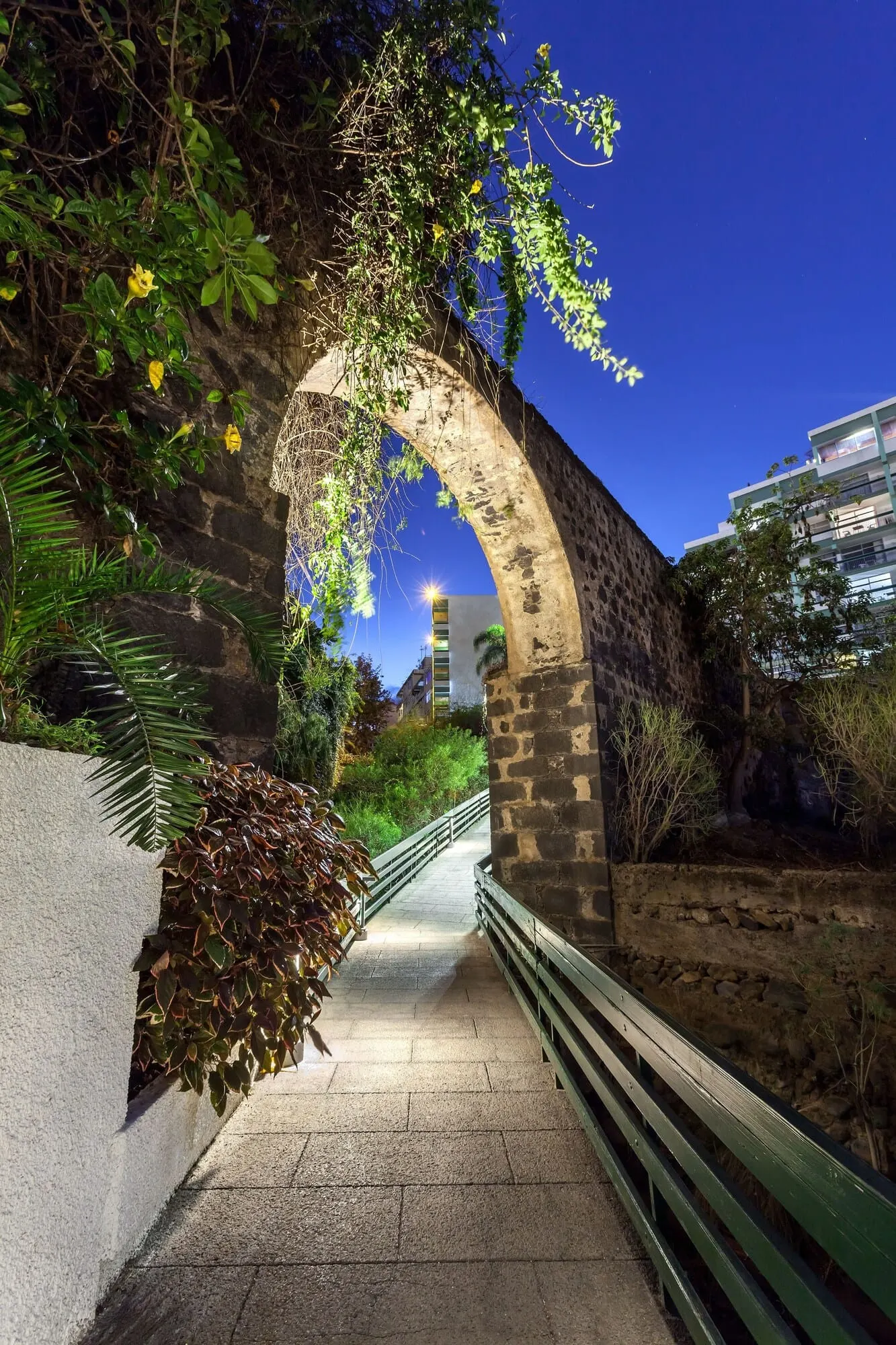 Parque Vacacional Eden: A stone archway with greenery and a pathway leading to a modern building