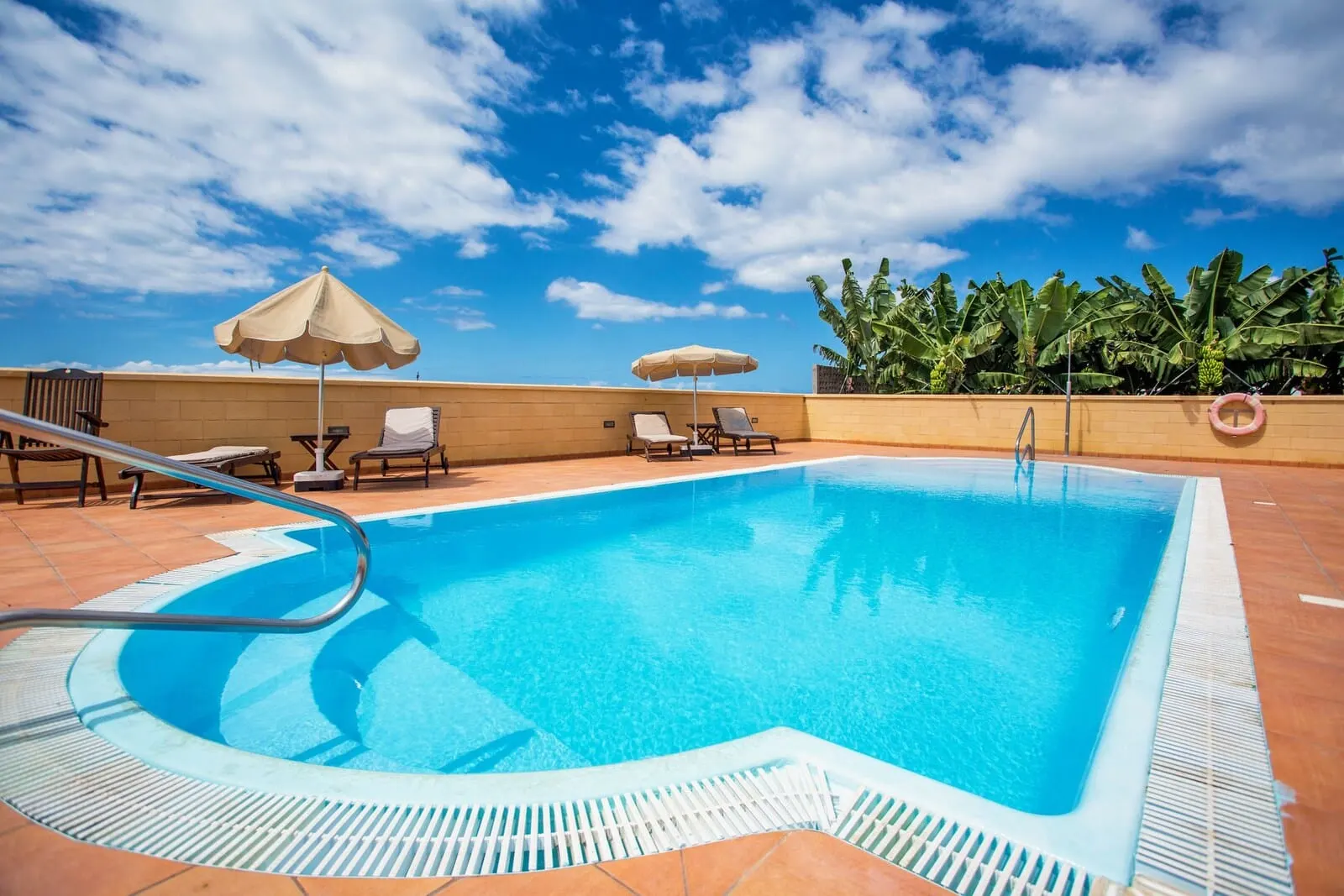 Hotel Rural El Navío: A rooftop pool with clear blue water, surrounded by lounge chairs and umbrellas