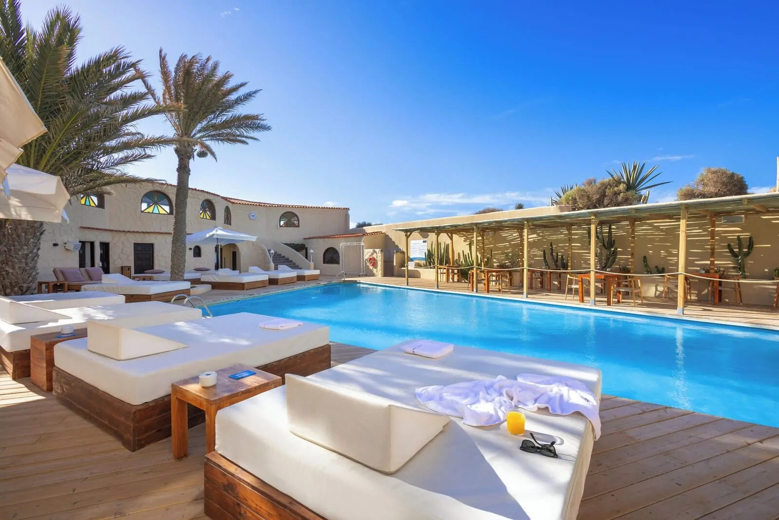 Playa Surf CBbC Hotel: A poolside area with lounge chairs and a wooden deck