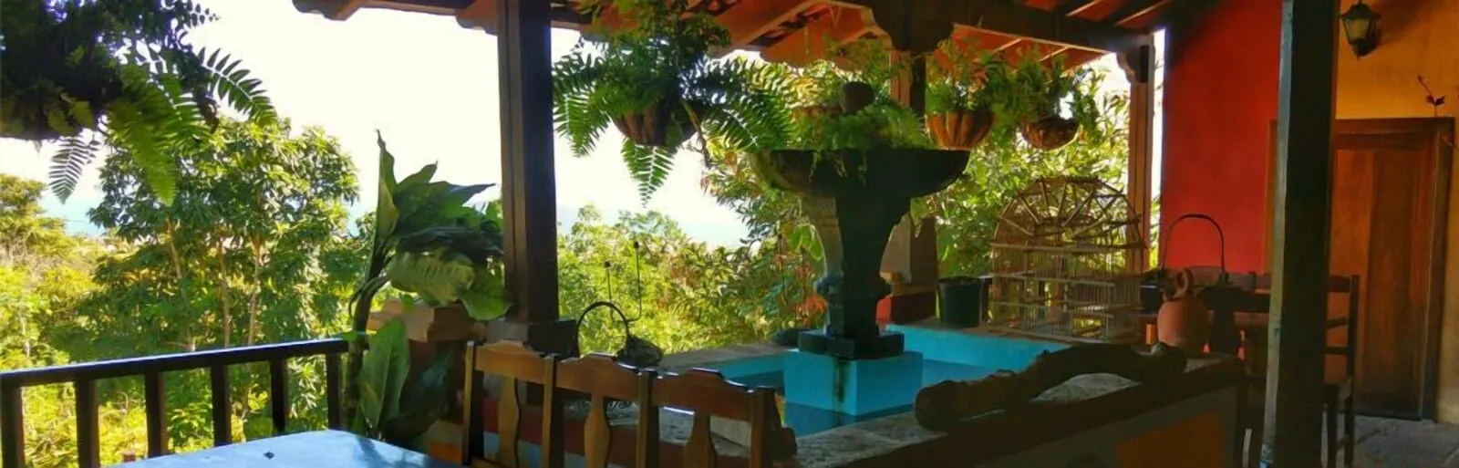 Hotel Rural La Raya 1866: A covered outdoor area with a pool, wooden chairs, and hanging plants