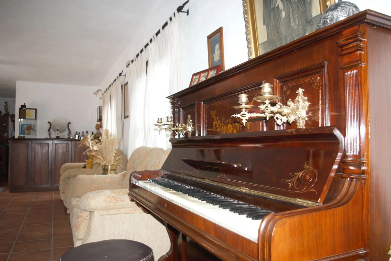 Hotel Rural El Navío: A grand piano in a living room with a tiled floor, a sofa