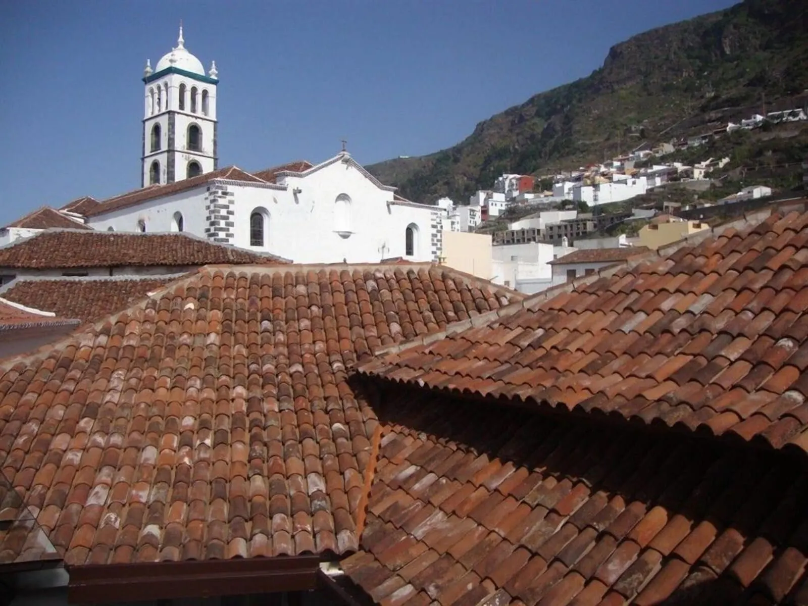 Isla Baja Suites: A building with a bell tower and terracotta tiled roofs