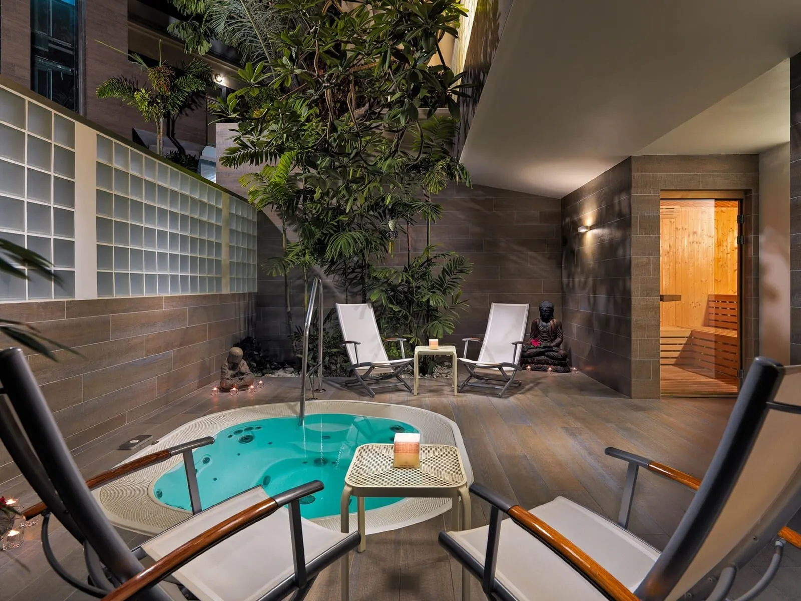 Hotel Colón Guanahaní: A spa area with a hot tub, two lounge chairs, and a statue