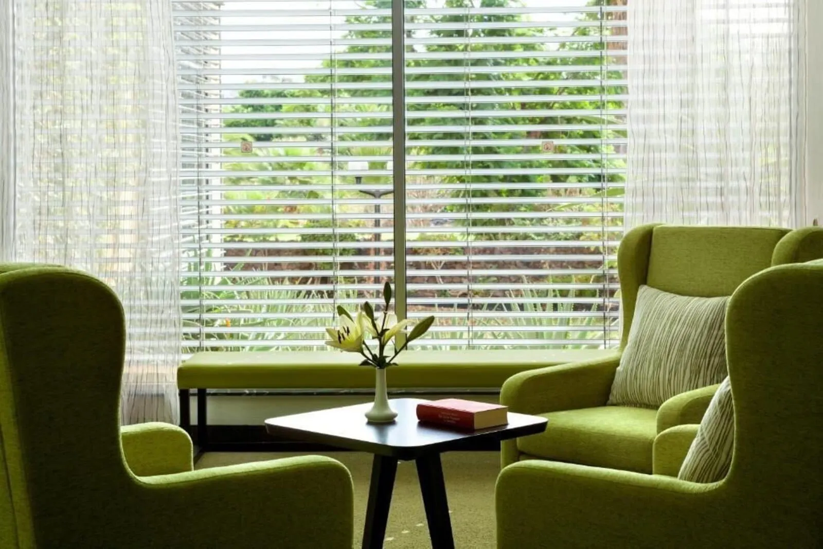 Hotel Tigaiga: A room with a green sofa, a small table with a vase and a book