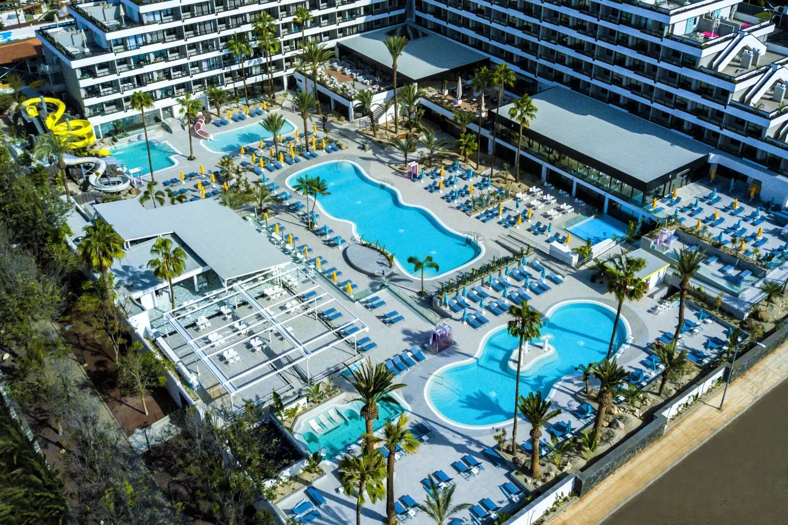 Spring Hotel Bitácora: A hotel with multiple swimming pools, sun loungers, and palm trees