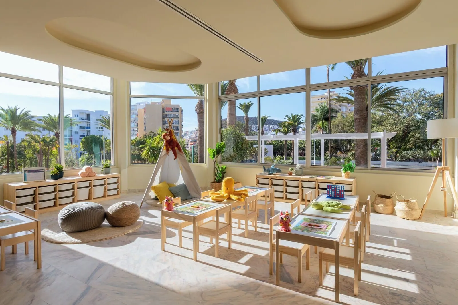 Sol Arona Tenerife: A bright, sunlit room with large windows, a play area with tables and chairs