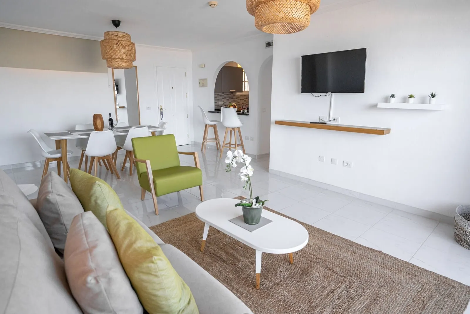 El Marqués Palace: A modern living room with a sofa, chairs, a coffee table, and a TV mounted on the wall