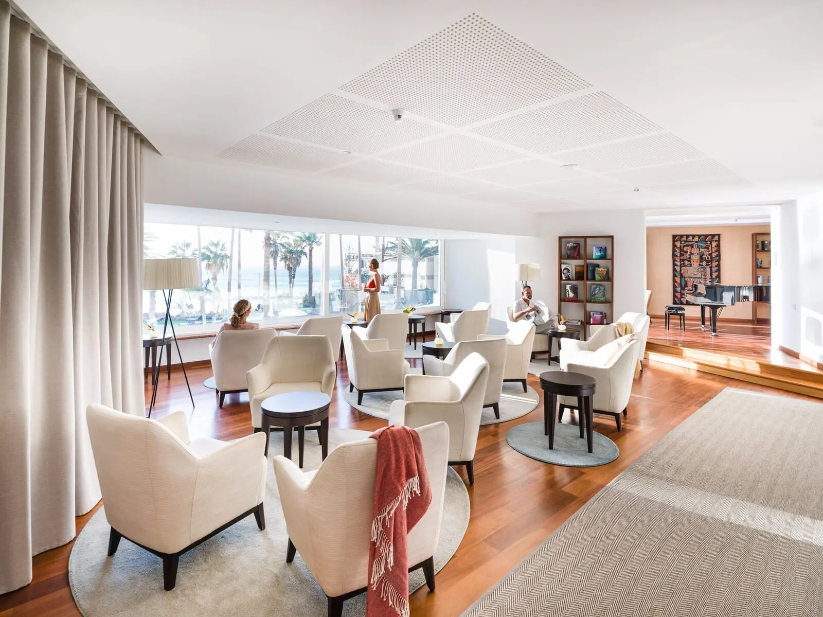 Océano Health Spa Hotel: A spacious living area with multiple seating options, a piano