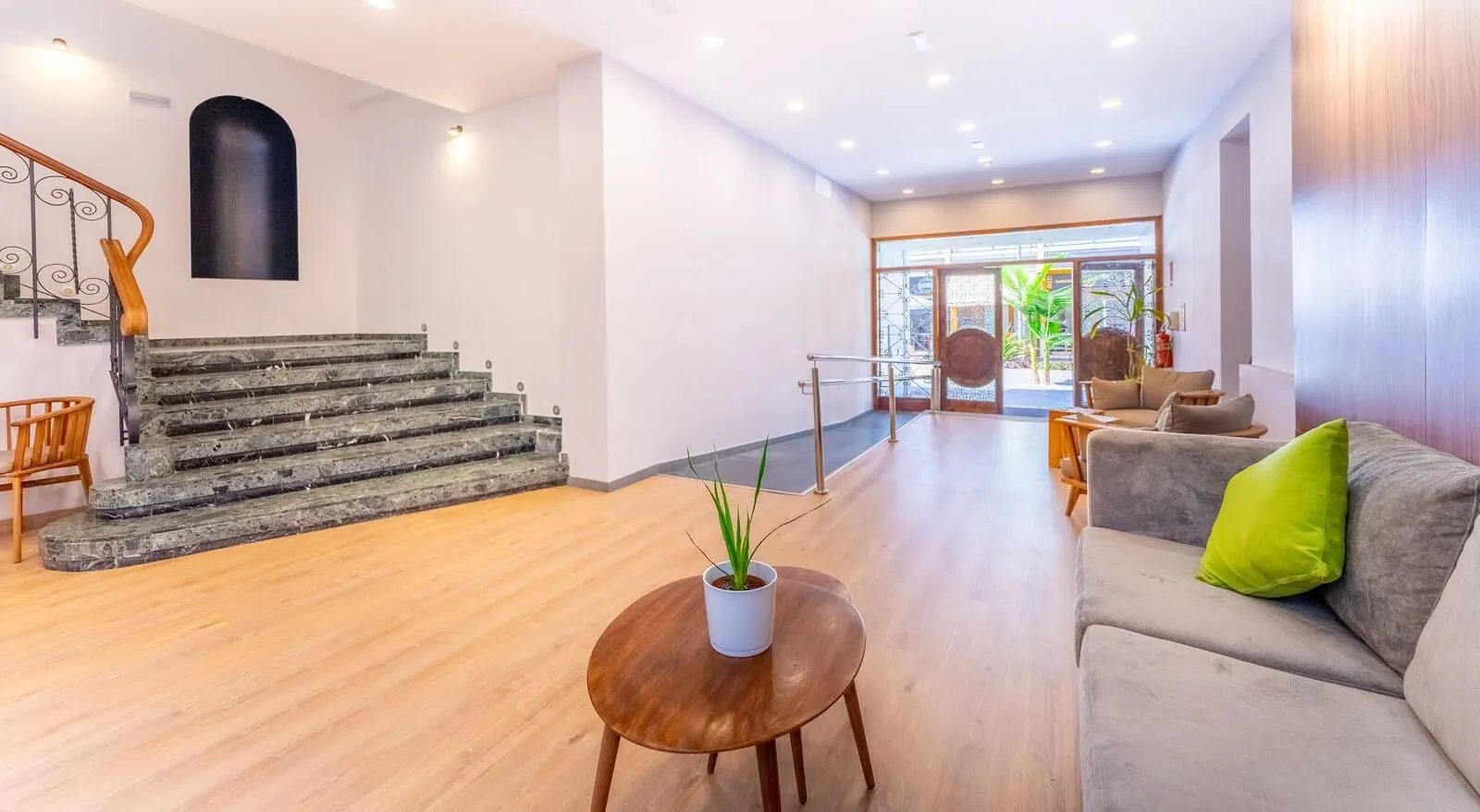 DWO Nopal: A spacious lobby with a staircase, a sofa, a coffee table, and a potted plant
