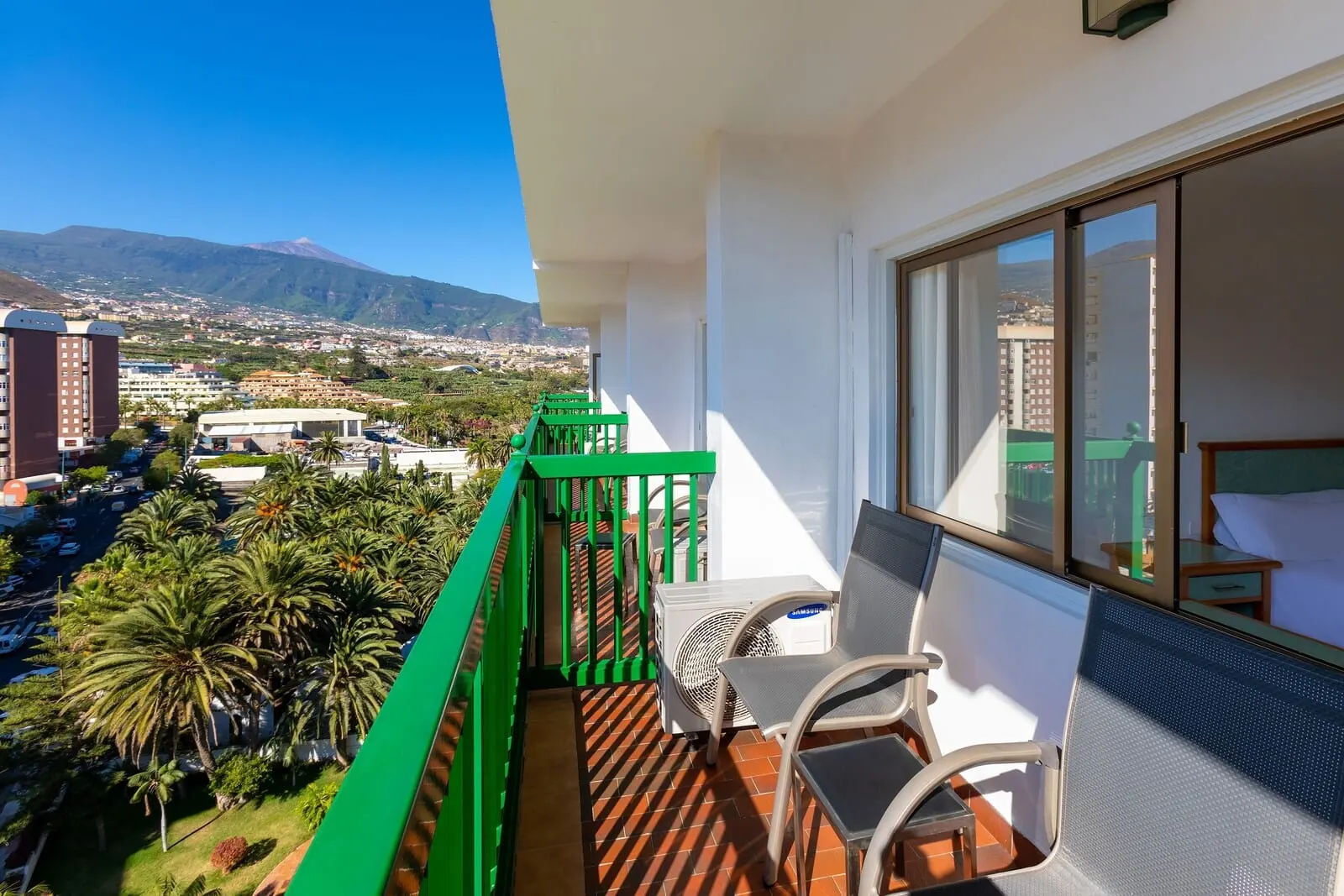 Sol Puerto de la Cruz Tenerife: A balcony with a view of a cityscape, including buildings and mountains