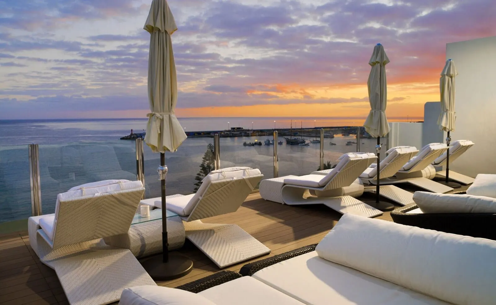 H10 Big Sur: A rooftop lounge with white lounge chairs and umbrellas