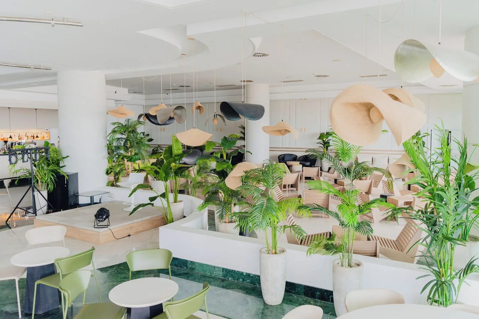 Landmar Costa Los Gigantes: A modern indoor space with round tables, green chairs, and potted plants