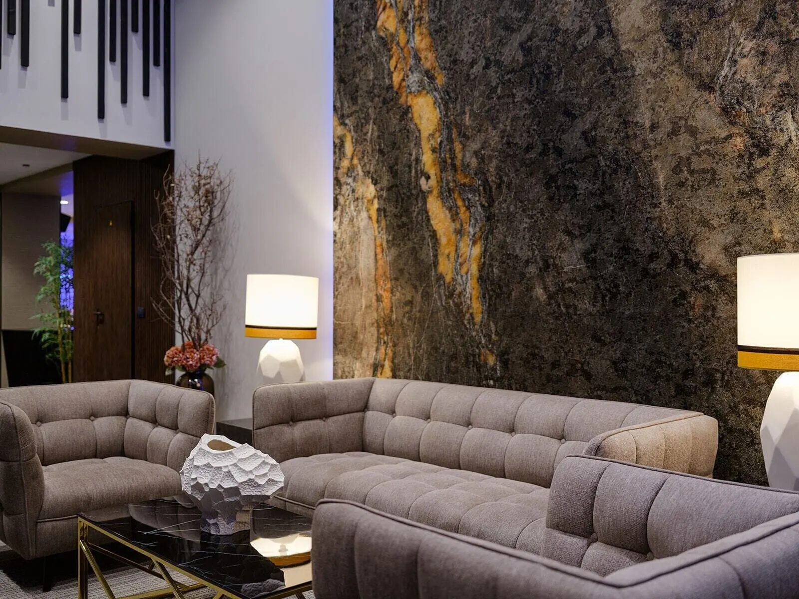 Hotel Taburiente: A modern living room with a sectional sofa, a coffee table, and two wall-mounted lamps
