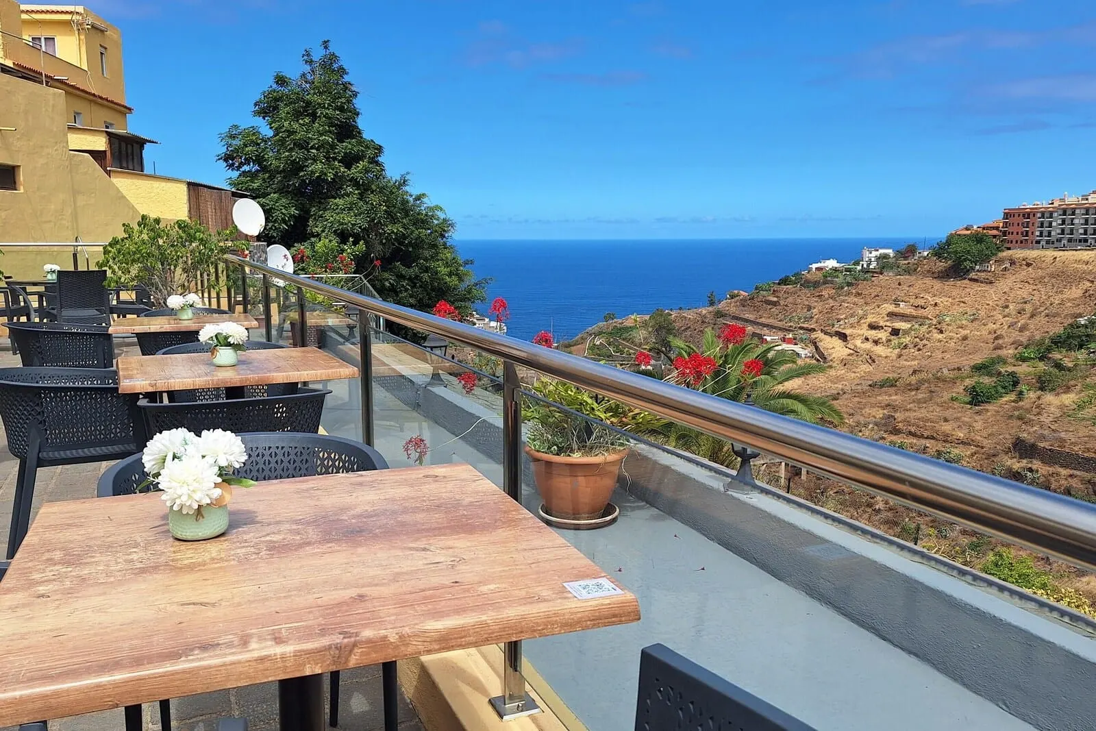 Hotel Rural Bentor: A terrace with outdoor seating, a railing, and a view of the sea