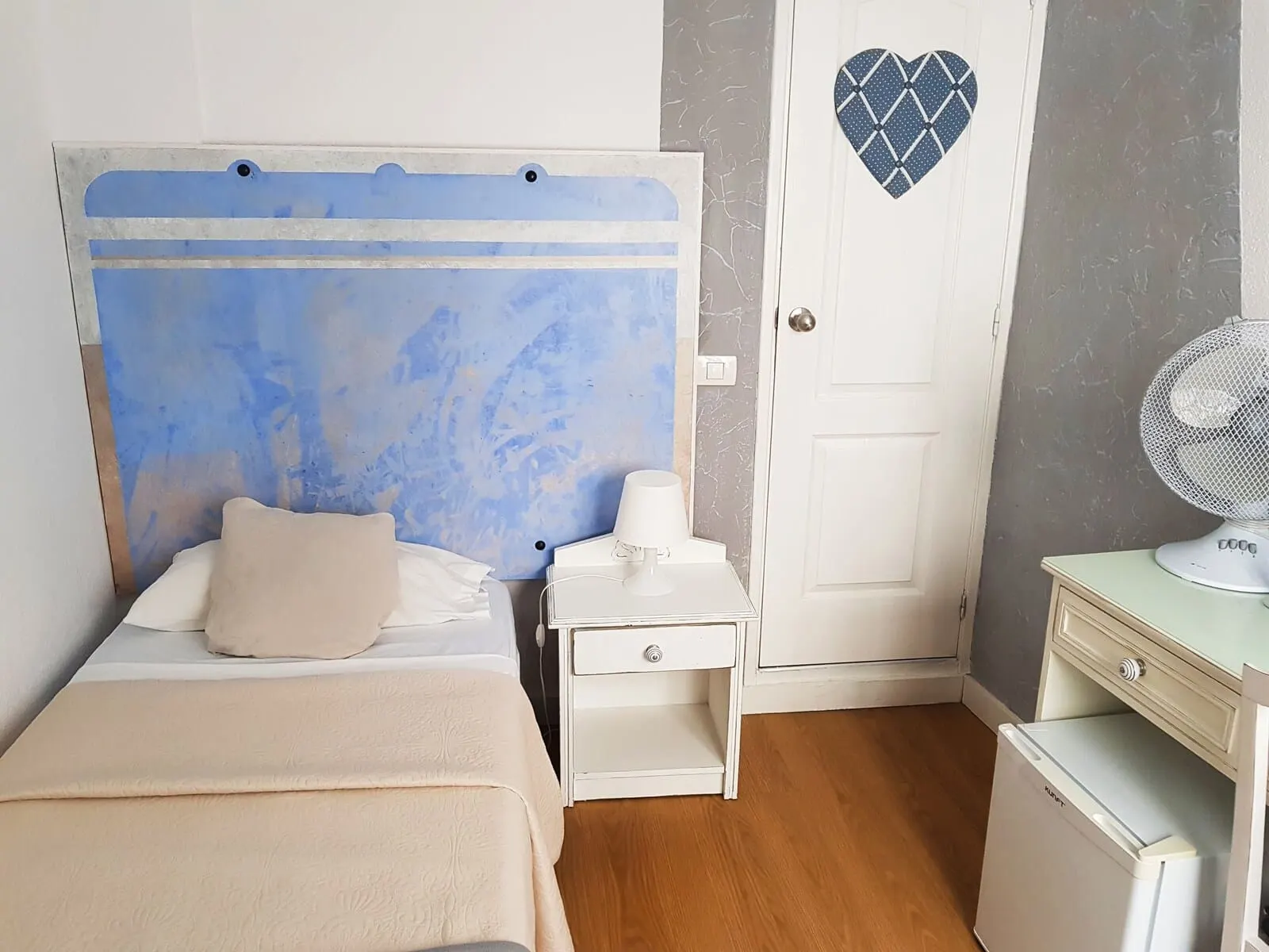 Nuevo Hotel Horizonte: A bedroom with a bed, bedside table, and a small refrigerator