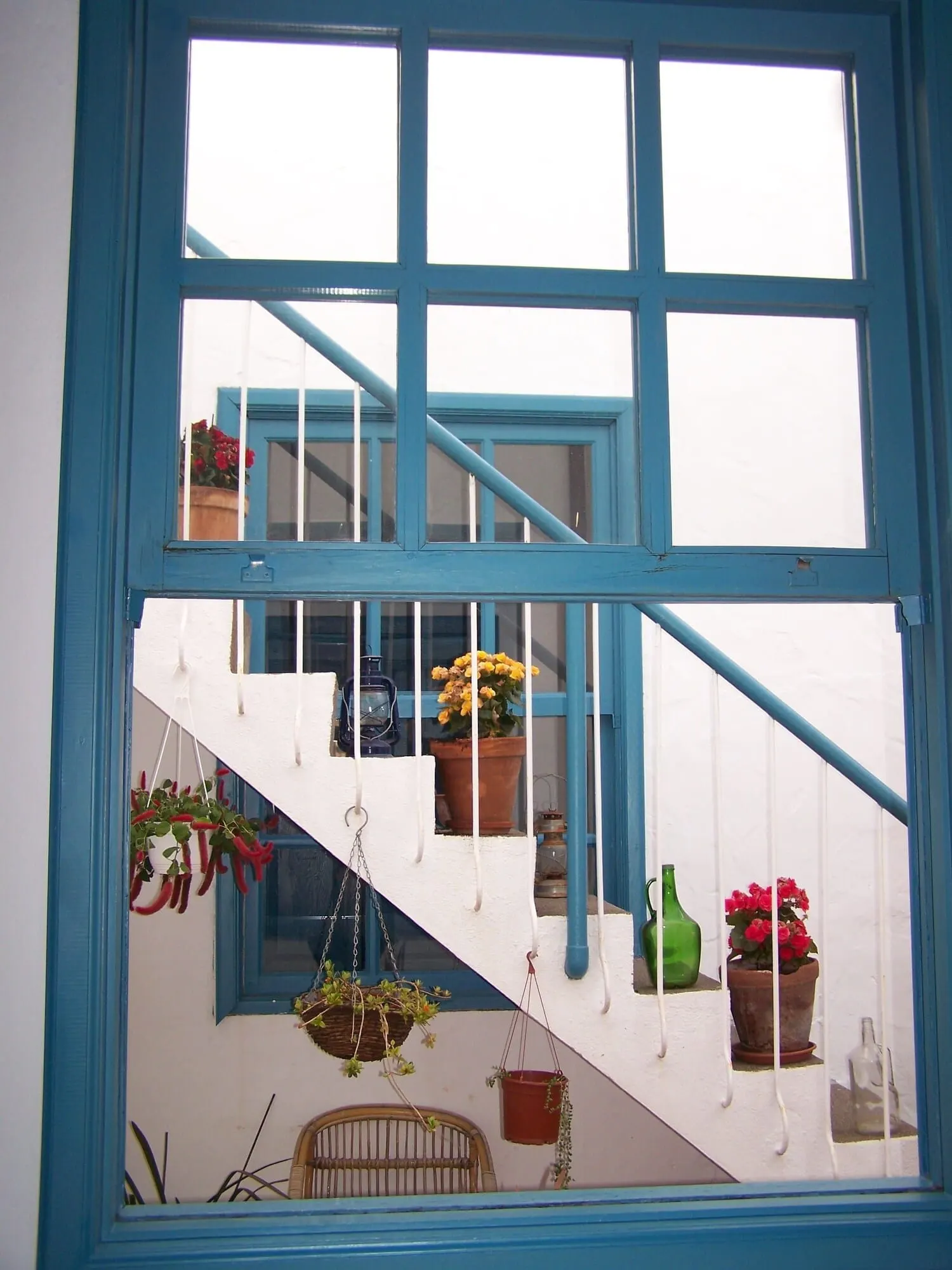 Hotel Cuatro Esquinas: A staircase with blue railings and white walls