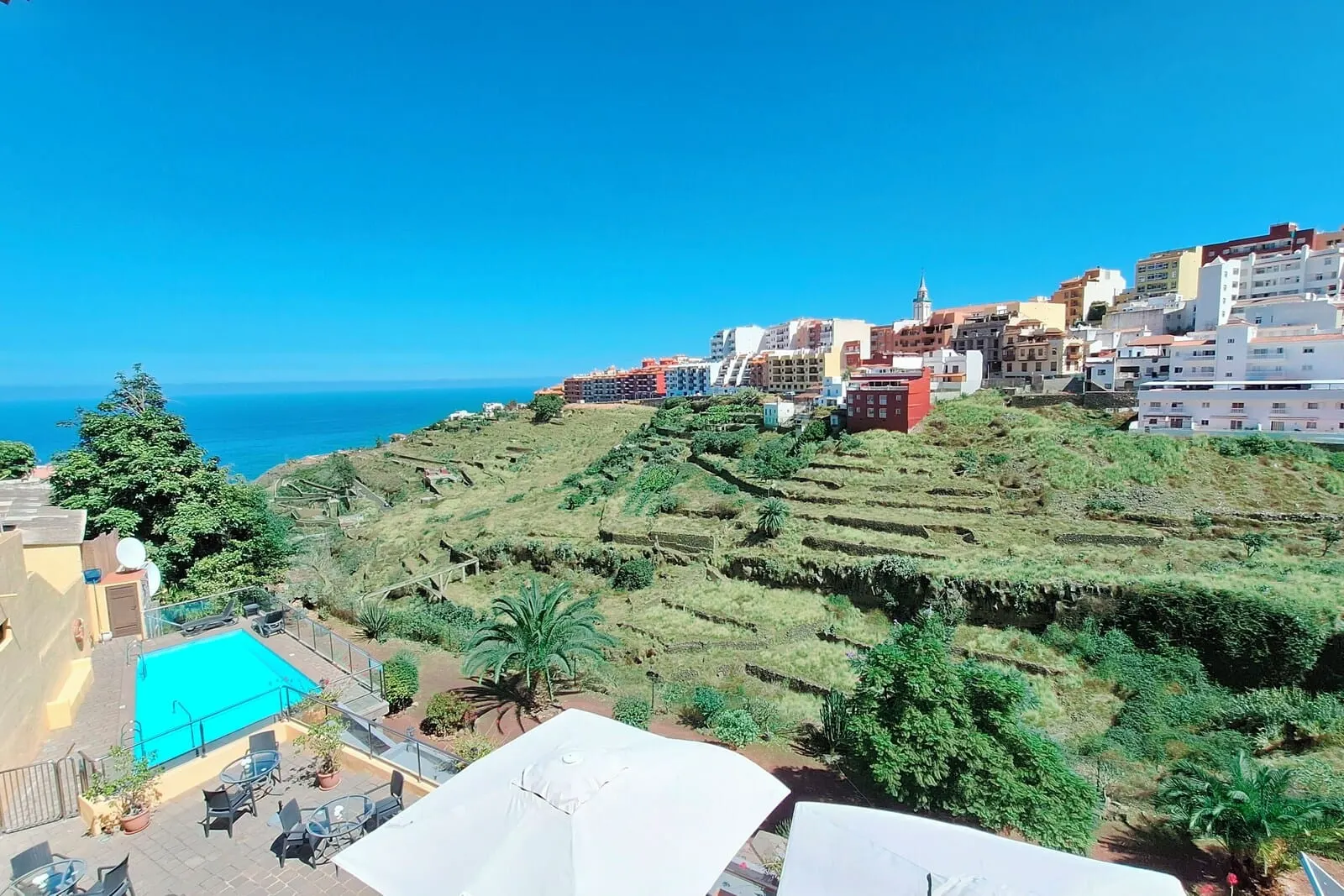 Hotel Rural Bentor: A coastal town with terraced fields, a swimming pool, and a view of the sea