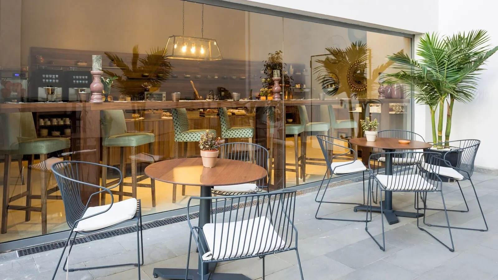 La Laguna Gran Hotel: An outdoor seating area with round tables and metal chairs, a potted plant