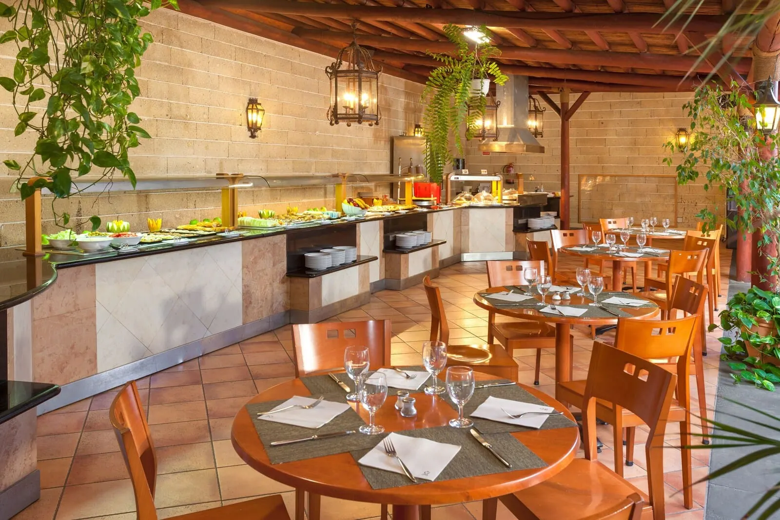 Sol Tenerife: A restaurant with a buffet, tables set for dining, and hanging plants