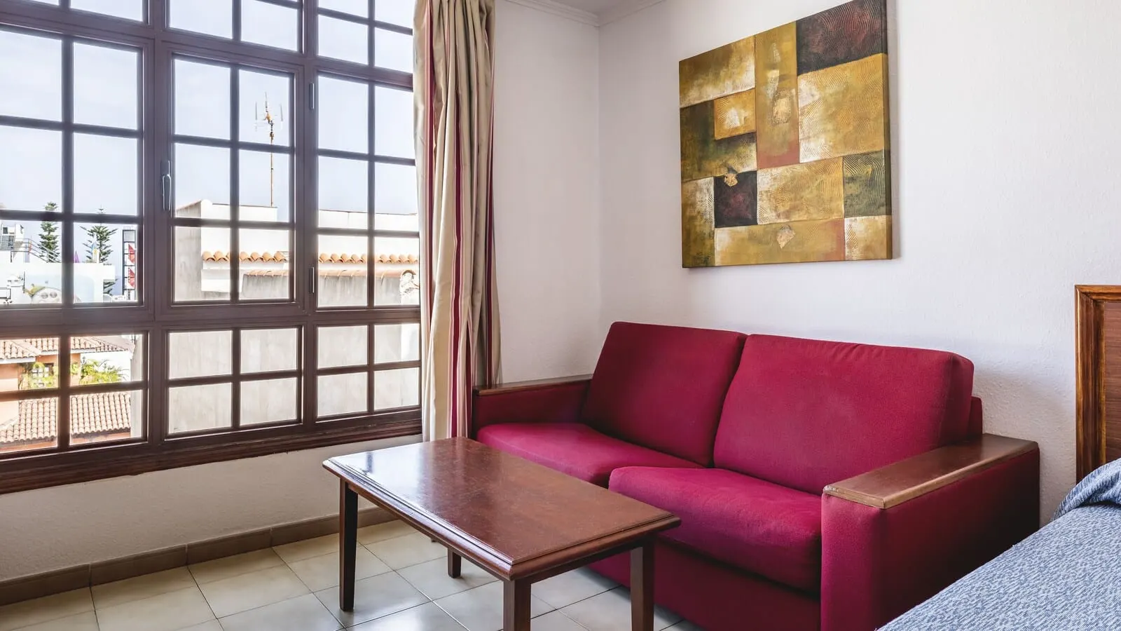 Be Smart Florida Plaza: A living room with a red sofa, a wooden coffee table, a large window with curtains