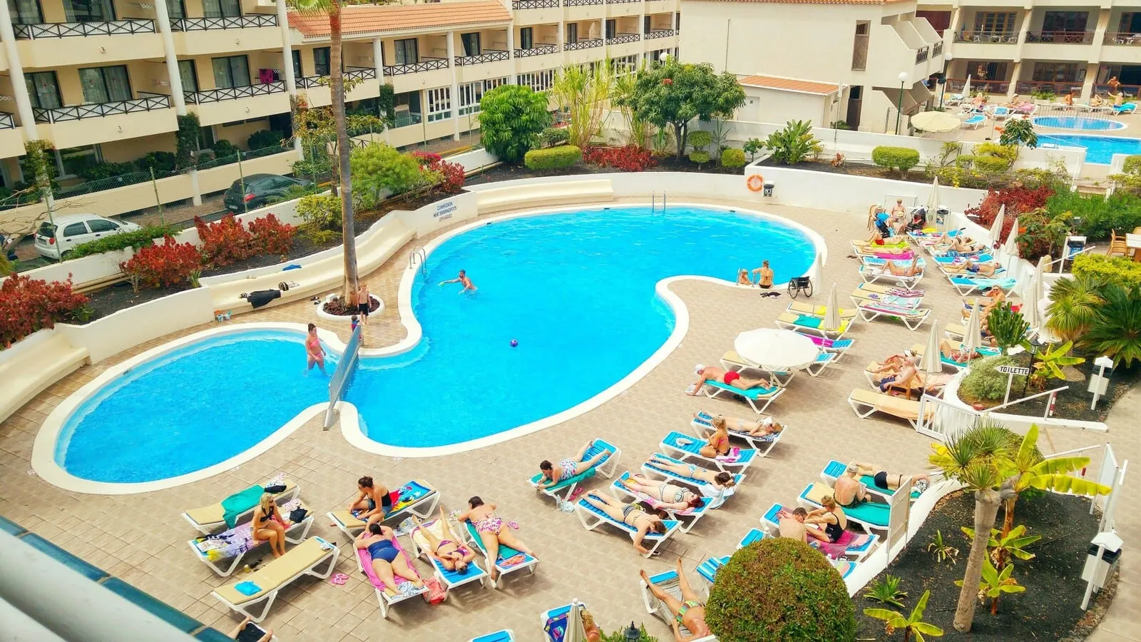 Hotel Andorra: A hotel pool area with multiple pools, sun loungers, and a covered seating area