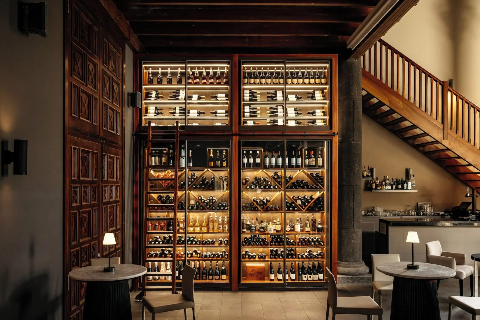 Hacienda del Conde Meliá Collection Golf & Spa: A bar area with a wine rack, seating, and a staircase
