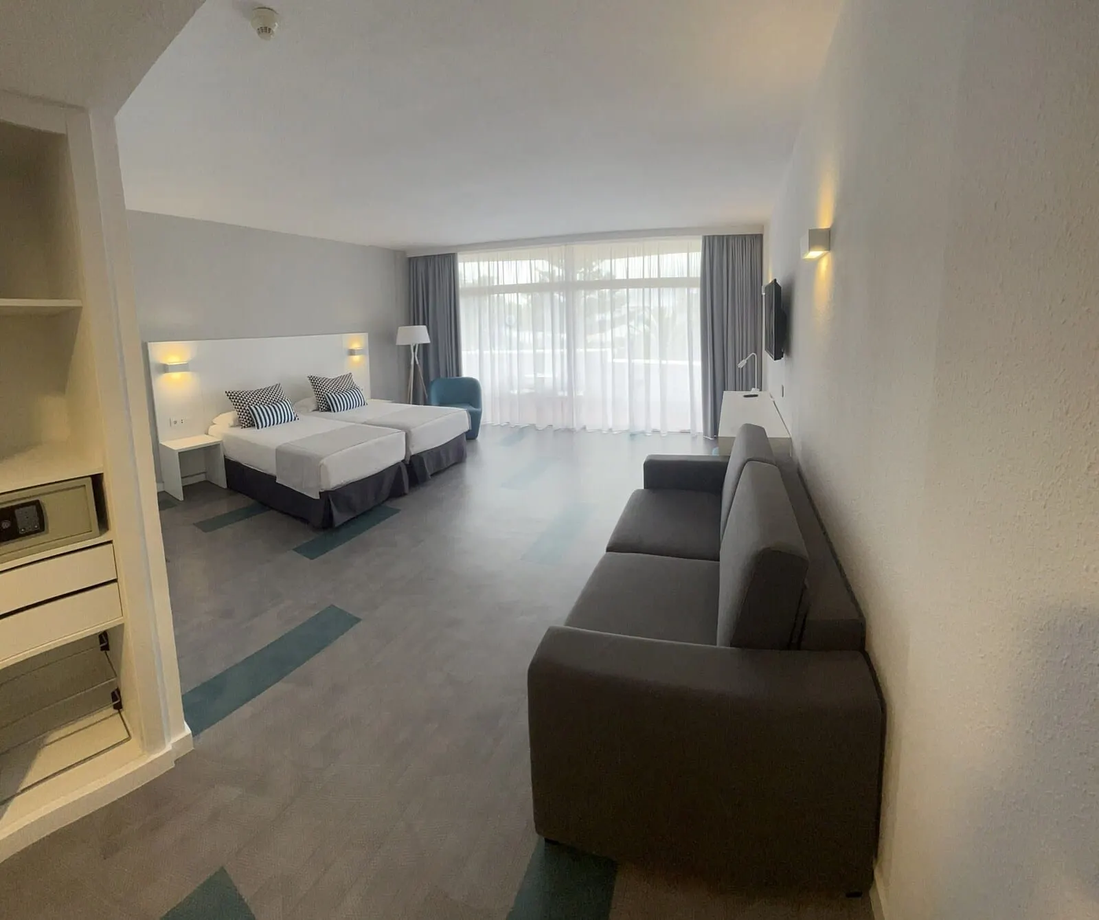 BLUESEA Puerto Resort: A hotel room with two beds, a sofa, a TV, and a desk