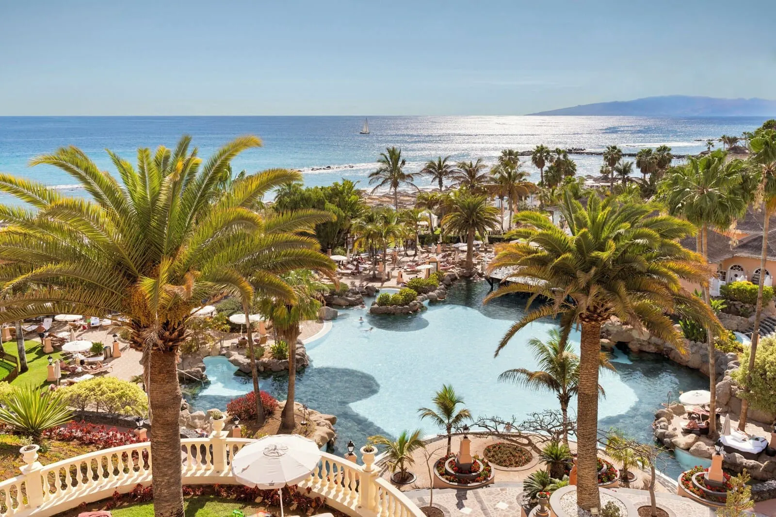Bahía del Duque: A resort with a large pool, palm trees, and a view of the ocean