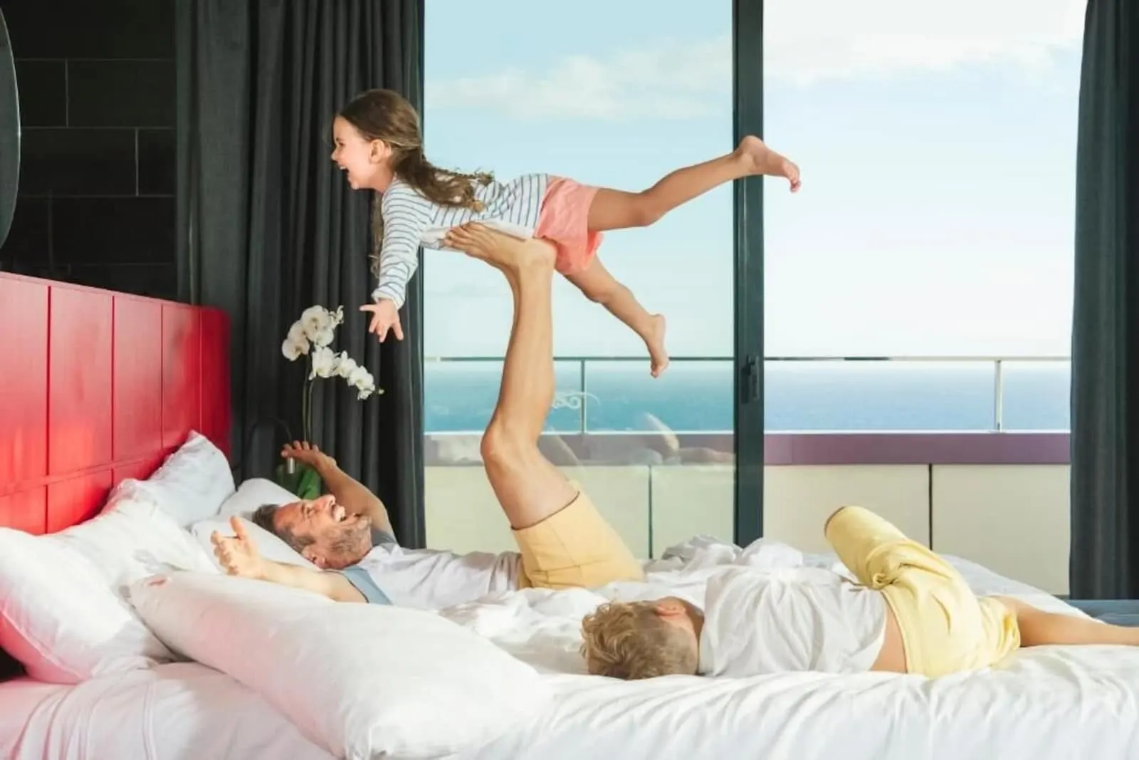 Hard Rock Hotel Tenerife: A bedroom with a bed, a window with a view, and a red headboard